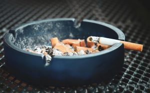 filfthy ashtray full of cigarette stubs